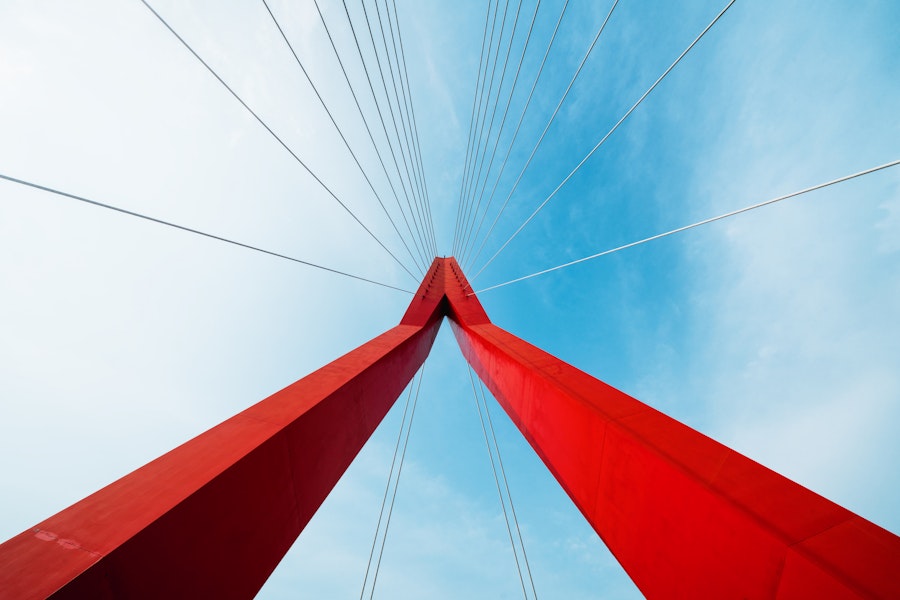 A view of the wires holding up a suspension bridge, showing how a framework is needed for structural integrity.
